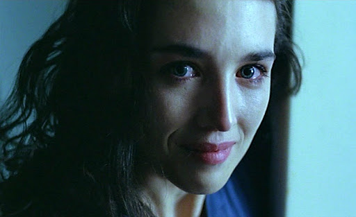 Screenshot from Possession - close up of a white woman's face, bathed in blue light. She is crying and smiling.